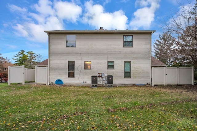 rear view of house with a yard and central air condition unit