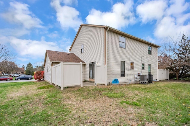 back of house featuring central AC and a lawn