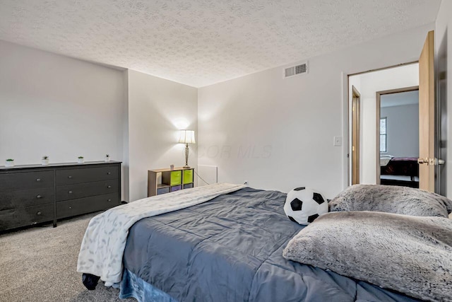 carpeted bedroom featuring a textured ceiling