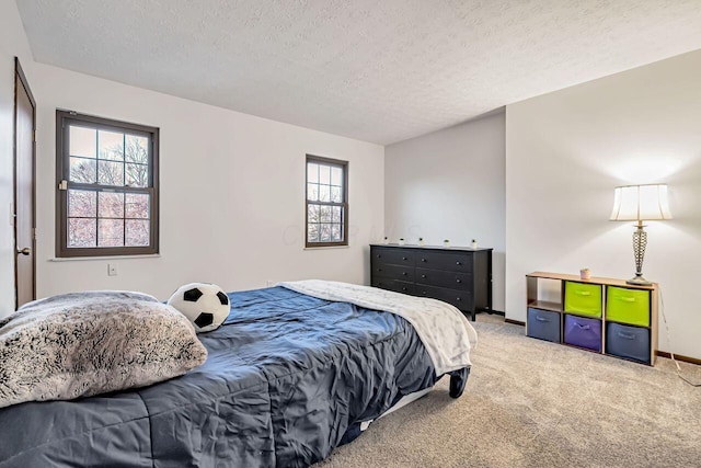 bedroom featuring carpet flooring, multiple windows, and a textured ceiling