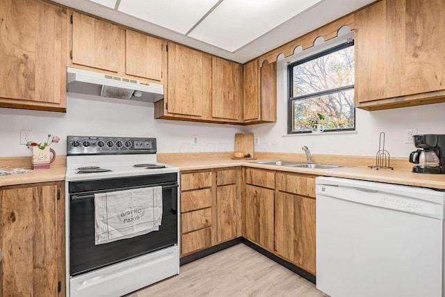 kitchen featuring light wood-type flooring, white appliances, and sink