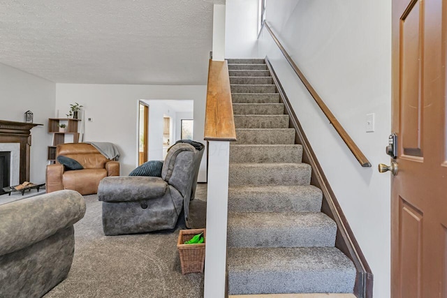 staircase with carpet floors and a textured ceiling