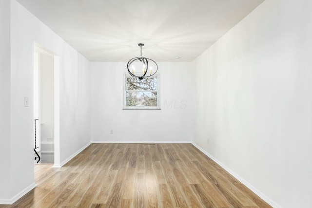 unfurnished dining area with a chandelier and light wood-type flooring