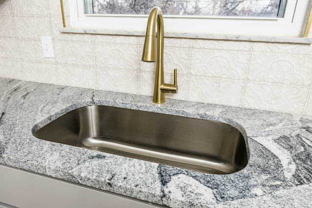 details featuring light stone countertops and sink