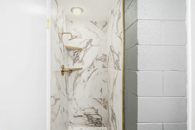 interior details with a tile shower