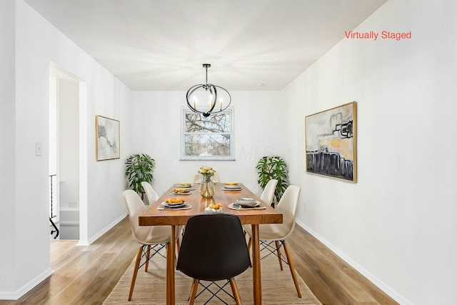 dining room featuring light hardwood / wood-style flooring and a notable chandelier