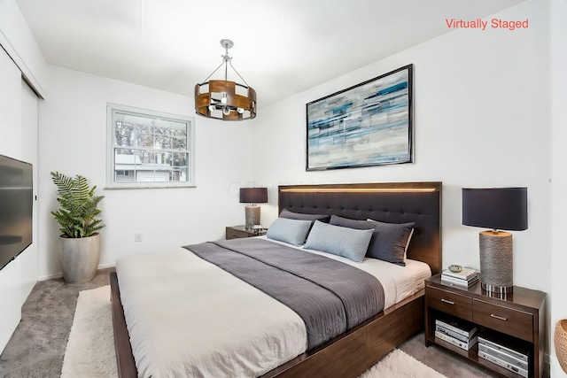 bedroom with light colored carpet and a notable chandelier