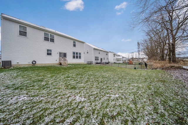 back of house featuring a lawn and central air condition unit