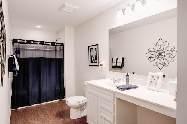 bathroom with vanity, hardwood / wood-style flooring, toilet, and walk in shower