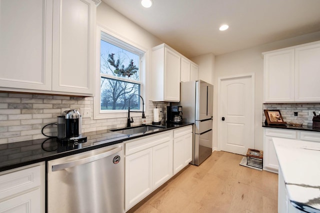 kitchen featuring backsplash, sink, white cabinets, and appliances with stainless steel finishes