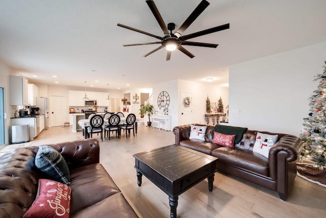 living room featuring ceiling fan and light wood-type flooring