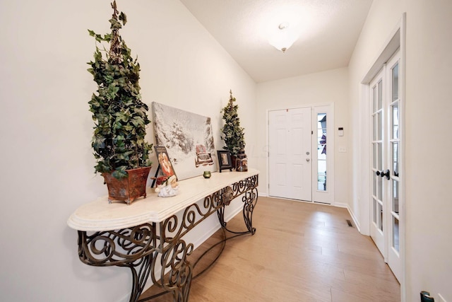 foyer featuring french doors and light hardwood / wood-style floors