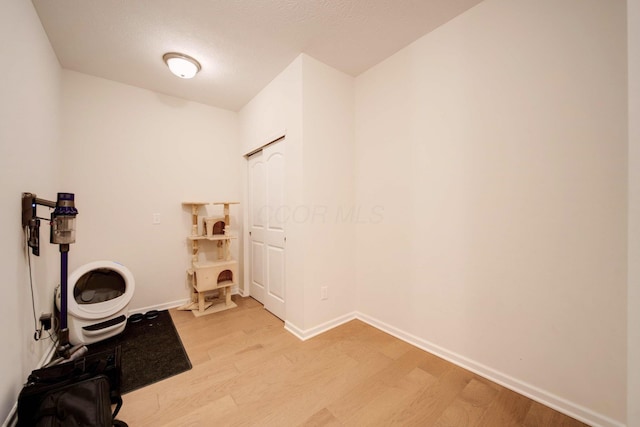 clothes washing area featuring light hardwood / wood-style floors