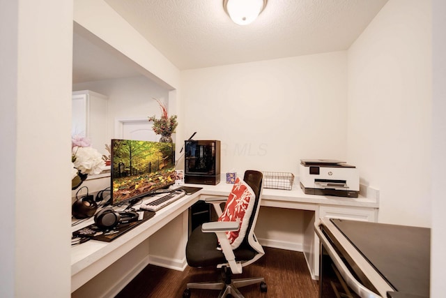 home office with a textured ceiling and dark hardwood / wood-style floors