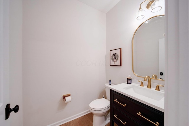 bathroom with vanity, wood-type flooring, and toilet