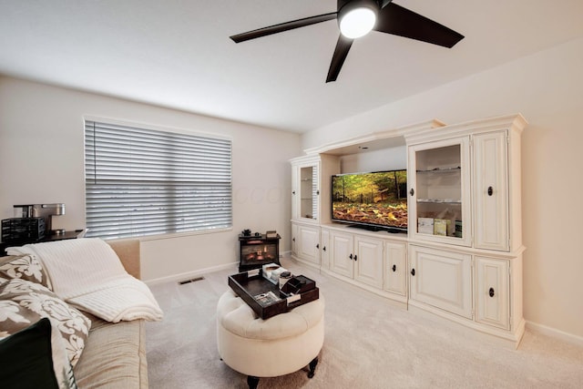 carpeted living room with ceiling fan