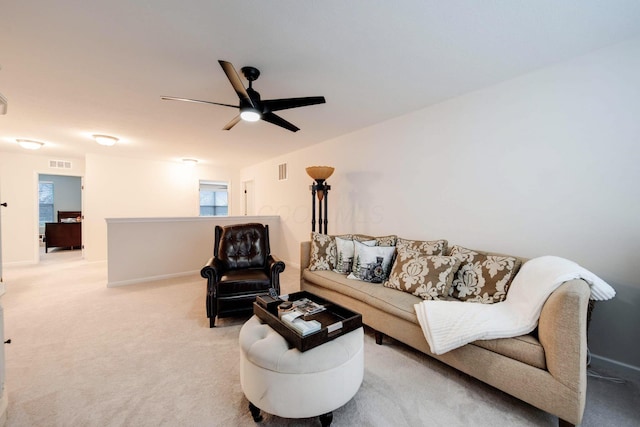 carpeted living room with ceiling fan