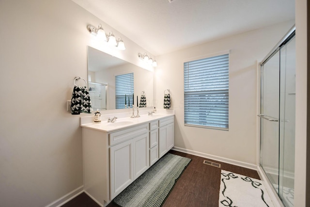 bathroom featuring vanity, wood-type flooring, and a shower with shower door