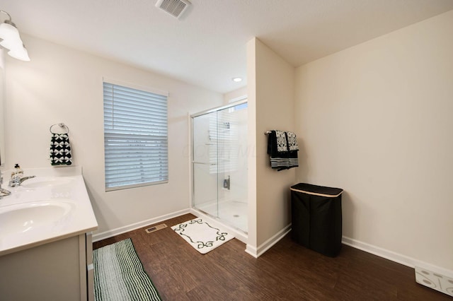 bathroom featuring hardwood / wood-style floors, vanity, and a shower with door