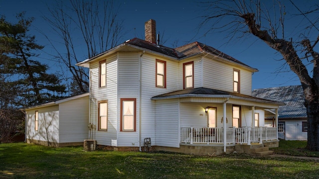 rear view of house featuring a porch and a yard