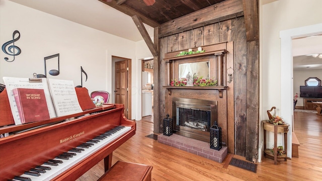 miscellaneous room featuring light hardwood / wood-style floors, wood ceiling, and a brick fireplace