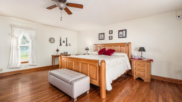 bedroom with dark hardwood / wood-style flooring and ceiling fan