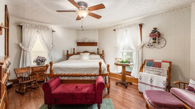 bedroom featuring hardwood / wood-style floors, a textured ceiling, and ceiling fan