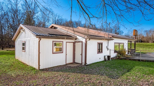 back of house featuring a lawn and central AC