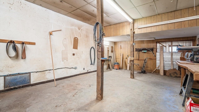 basement featuring a workshop area and wood walls