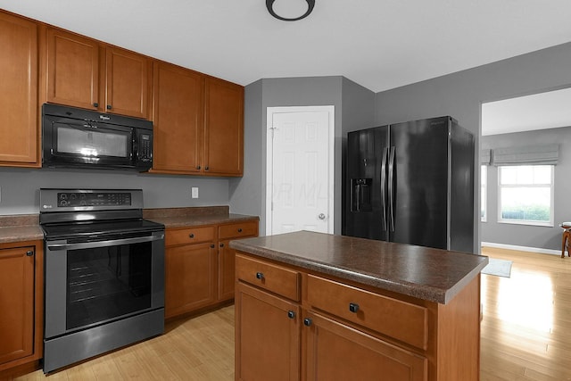 kitchen featuring a center island, light hardwood / wood-style flooring, and black appliances