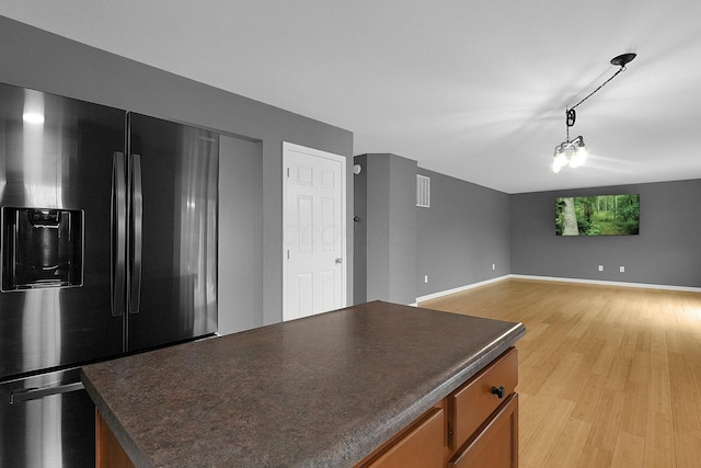 kitchen featuring an inviting chandelier, refrigerator with ice dispenser, and light hardwood / wood-style floors