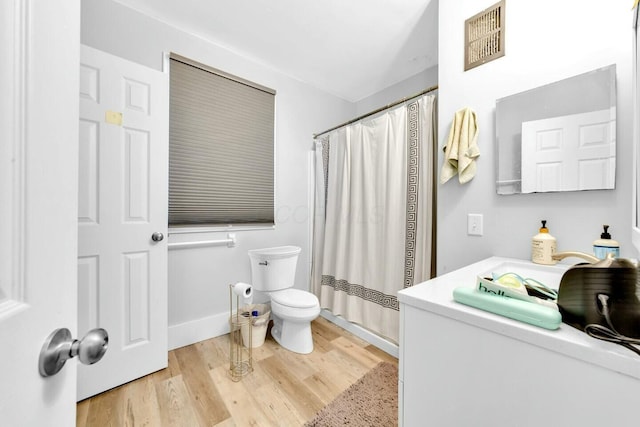 bathroom with curtained shower, vanity, wood-type flooring, and toilet