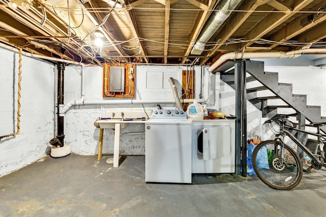 basement featuring washing machine and dryer and electric panel