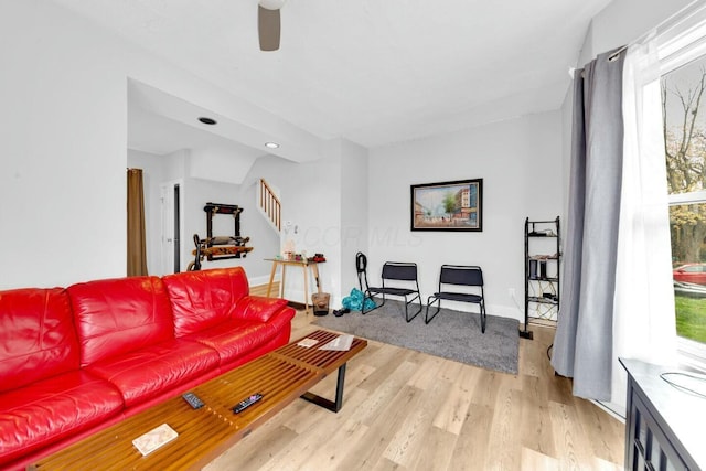 living room with ceiling fan and light hardwood / wood-style flooring