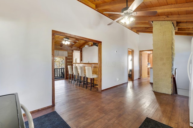 empty room with vaulted ceiling with beams, ceiling fan, wooden ceiling, and dark wood-type flooring