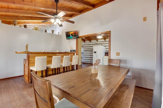 dining area featuring wood-type flooring, lofted ceiling with beams, ceiling fan, and wood ceiling