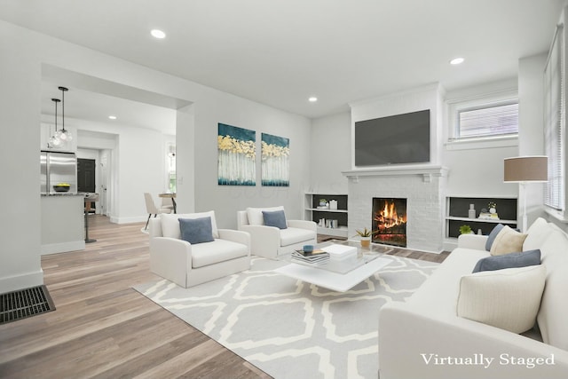 living room featuring a fireplace and light hardwood / wood-style flooring