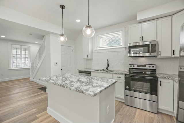 kitchen featuring sink, white cabinets, stainless steel appliances, and light wood-type flooring