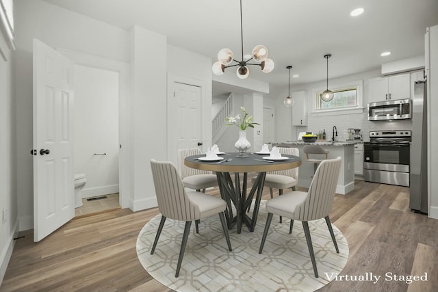 dining space with a chandelier and light wood-type flooring