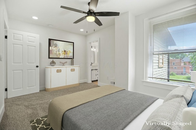 carpeted bedroom with connected bathroom, multiple windows, and ceiling fan