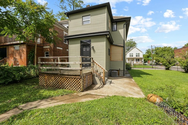 back of house with a lawn, a wooden deck, and central AC