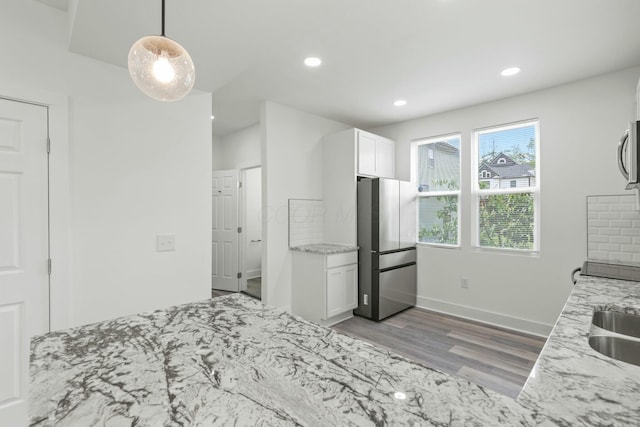 bedroom with stainless steel fridge, sink, and light hardwood / wood-style floors