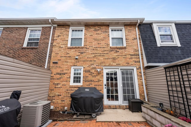 back of property with central AC unit and a patio area