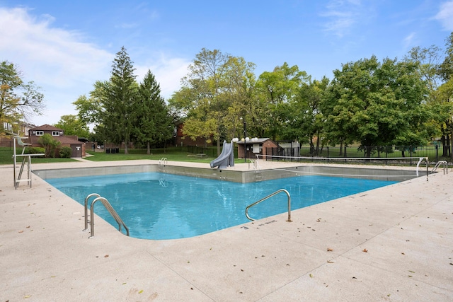 view of swimming pool with a patio and a water slide