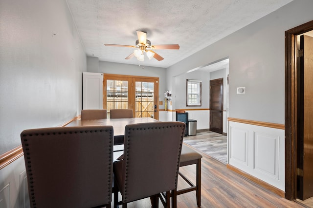 dining room with a textured ceiling, light wood-type flooring, and ceiling fan