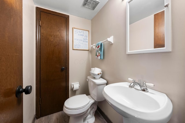 bathroom with toilet, sink, and hardwood / wood-style flooring