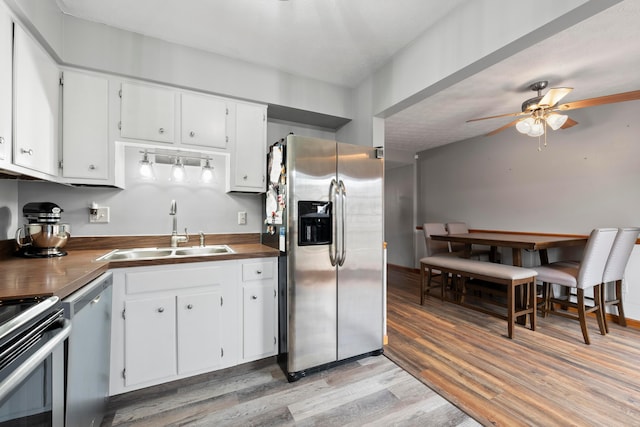 kitchen featuring sink, white cabinets, light hardwood / wood-style floors, and appliances with stainless steel finishes