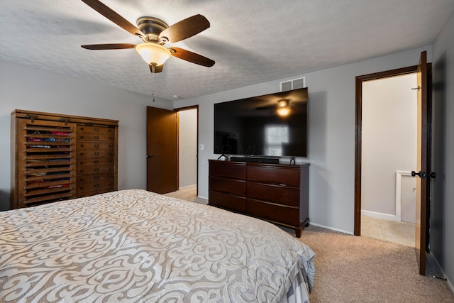 bedroom featuring ceiling fan, light carpet, and a textured ceiling