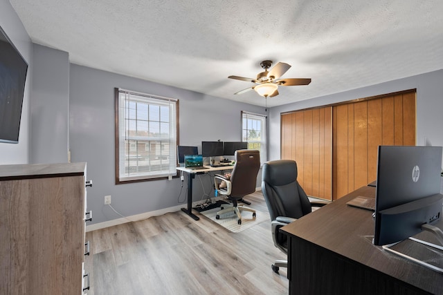 office area featuring a textured ceiling, light hardwood / wood-style floors, a wealth of natural light, and ceiling fan