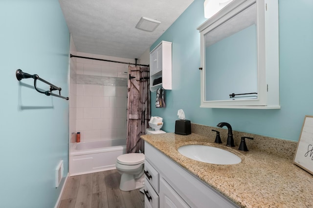 full bathroom with a textured ceiling, vanity, shower / tub combo with curtain, hardwood / wood-style floors, and toilet